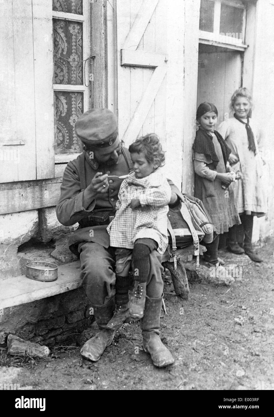 Deutscher Soldat füttert einen französischen junge, 1914 Stockfoto