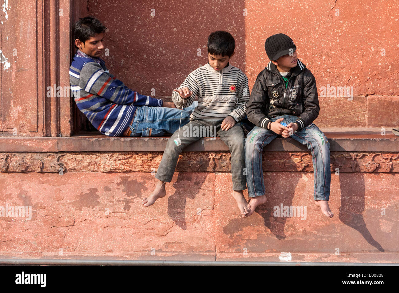 Neu-Delhi, Indien. Junge mit Yo-yo beim Sitzen mit Freunden in der Jama Masjid (Freitagsmoschee) spielen. Stockfoto