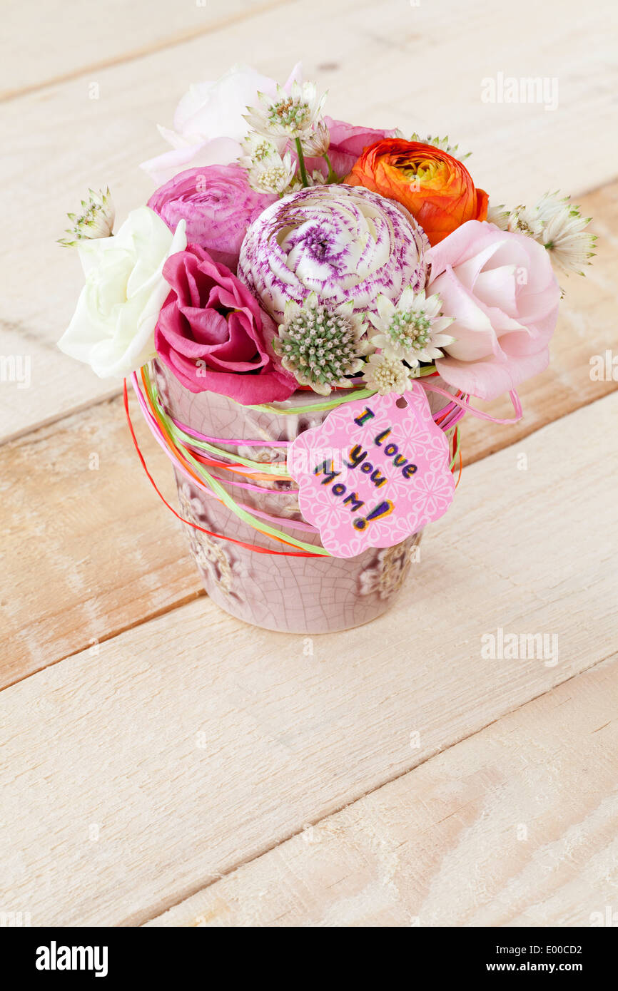 Schöner Blumenstrauß Frühlingsblumen in Blumentopf und eine Karte mit dem Text "Ich liebe dich Mama" Stockfoto
