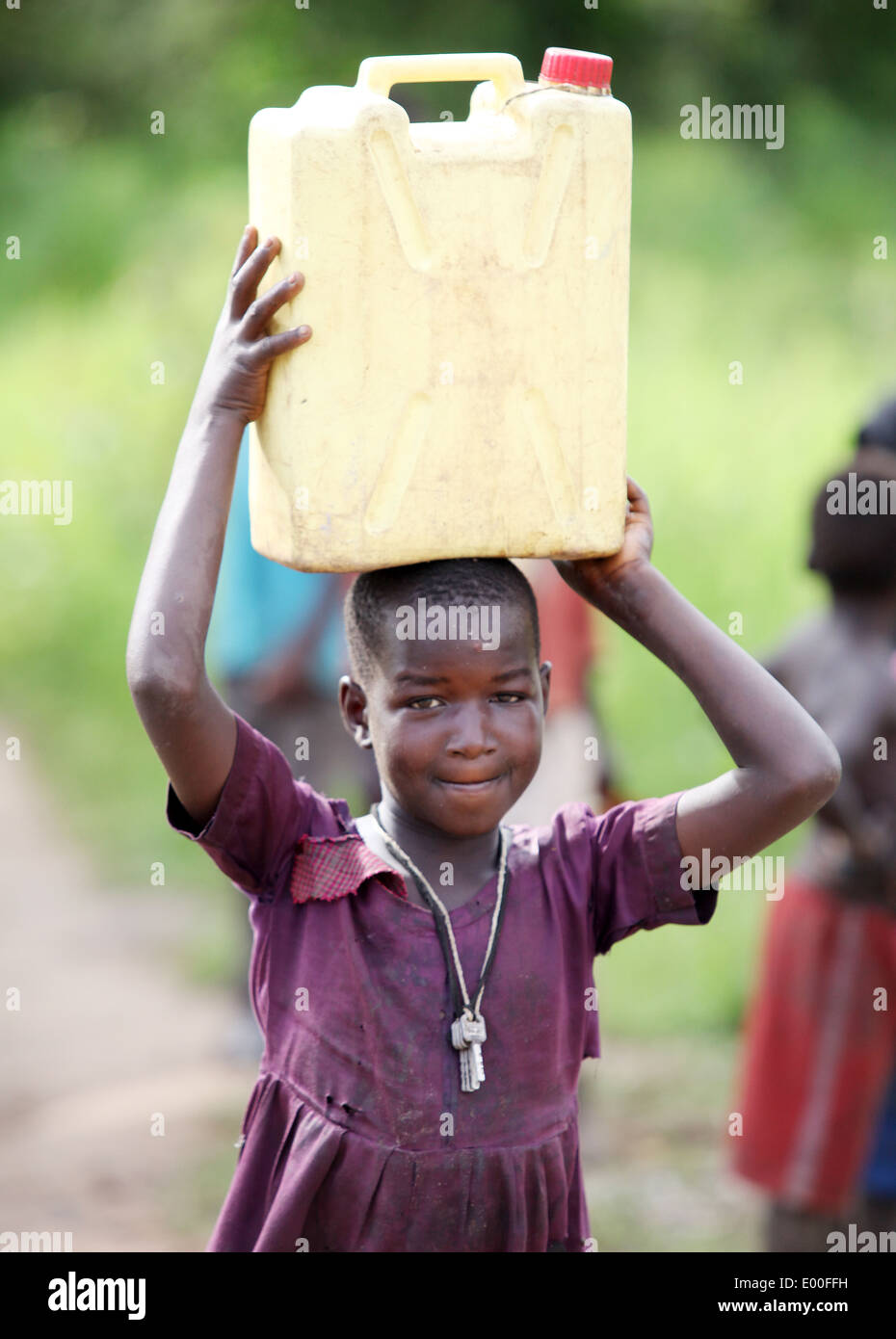 Kinder sammeln Wasser aus einer unreinen Regierung Wasserquelle in den Kosovo Slumviertel der Stadt Kampala in Uganda. Stockfoto