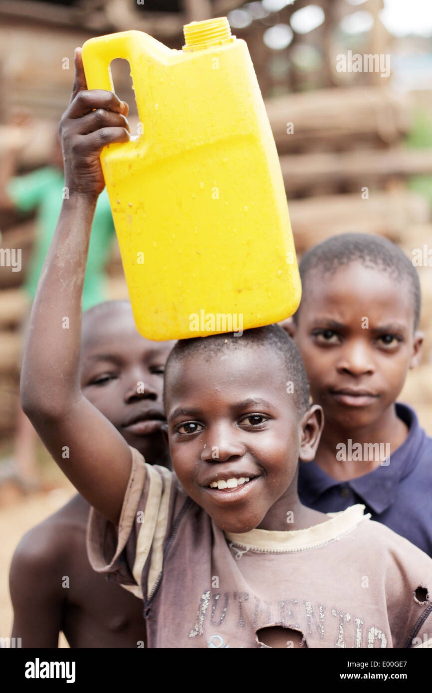 Kinder sammeln Wasser aus einer unreinen Regierung Wasserquelle in den Kosovo Slumviertel der Stadt Kampala in Uganda. Stockfoto