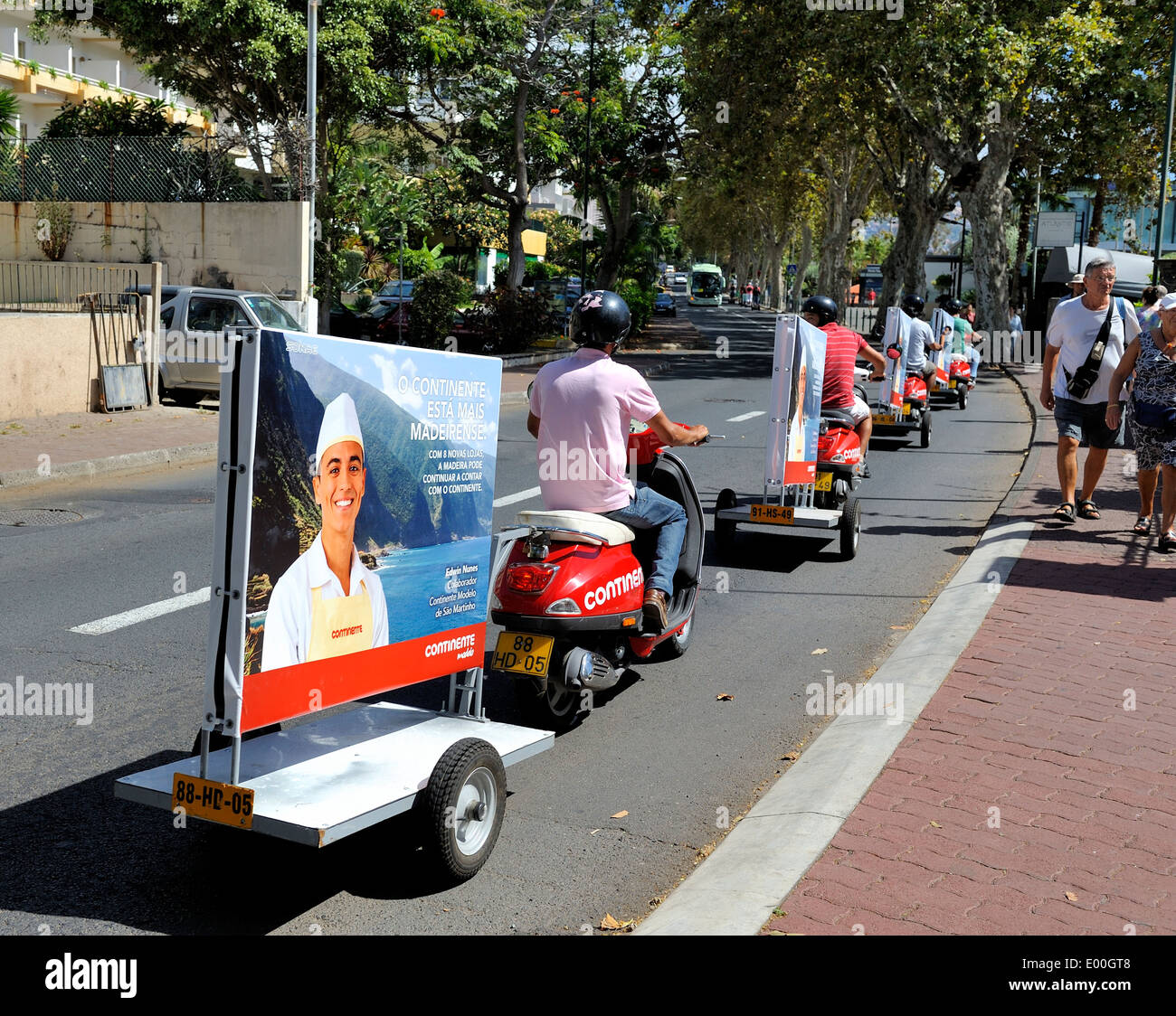 Madeira Portugal Arbeiter auf Mopeds ziehen Werbetafeln für den Supermarkt Continente Modelo Stockfoto