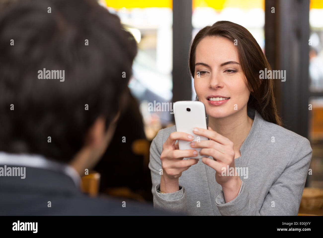 Weiblich männlich fröhlich Smartphone Abendessen bar Sms SMS Surfen web Stockfoto