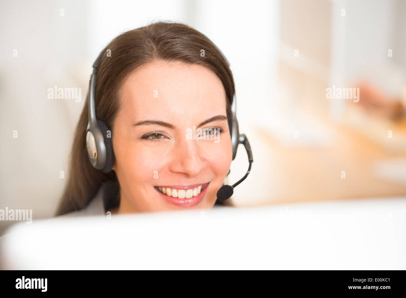 lächelnde weibliche hübsche Schreibtisch Kopfhörer Porträt Stockfoto
