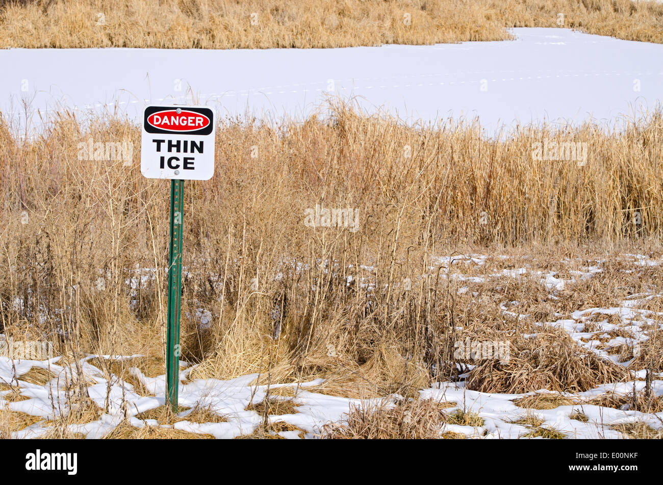 Dünnem Eis Warnung Warnschild in der Nähe von gefrorenen Teich im Winter, Aurora Colorado uns. Stockfoto