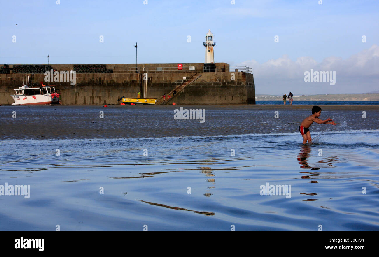 Kleiner Junge spielt im Meer in St Ives Harbour in Cornwall Stockfoto