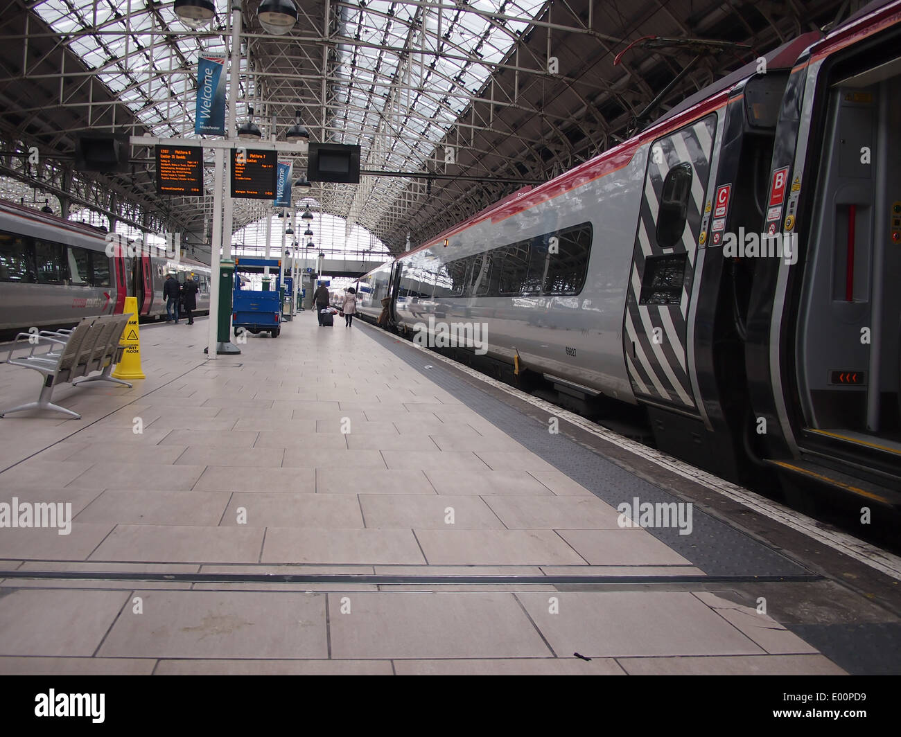 Eine Plattform im Piccadilly Bahnhof Manchester mit einem jungfräulichen Pendolino stehen dabei. Stockfoto