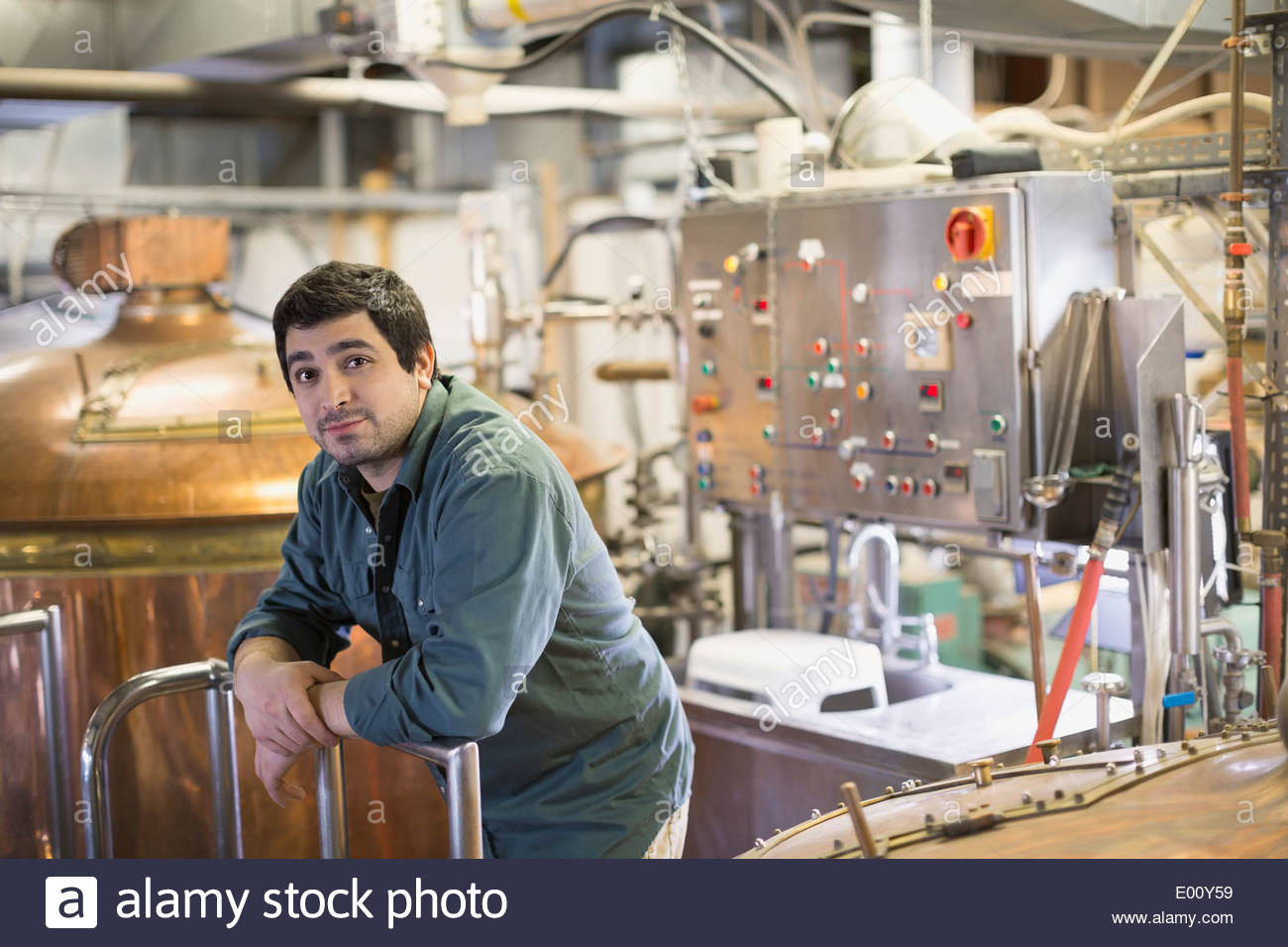 Porträt des Arbeitnehmers zuversichtlich Brauerei in der Nähe von Destillierapparaten aus Kupfer Stockfoto