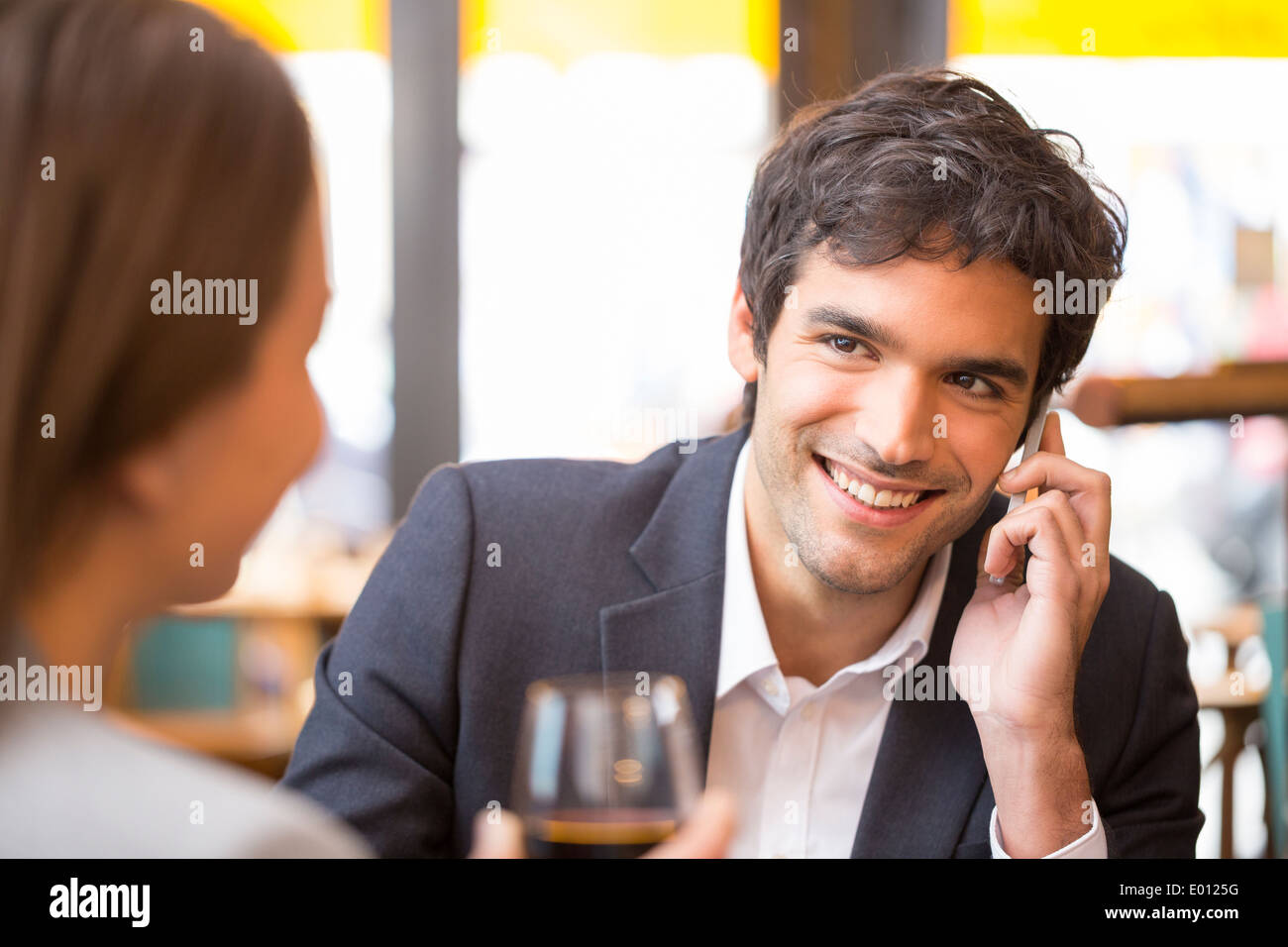 Weiblich männlich fröhlich Smartphone Abendessen bar Stockfoto
