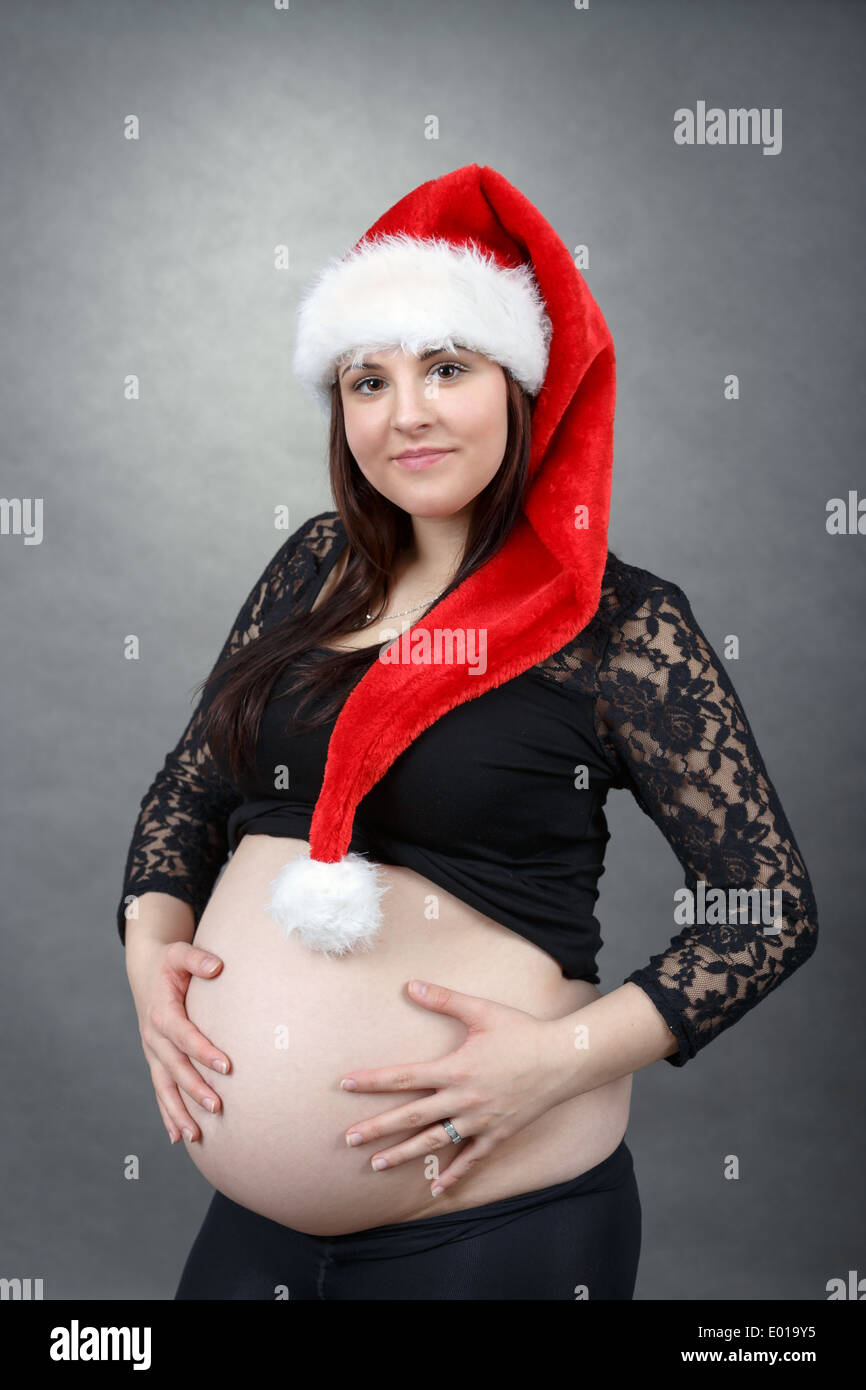 schöne junge Santa schwangeren Bauch zärtlich hält lächelnd Stockfoto