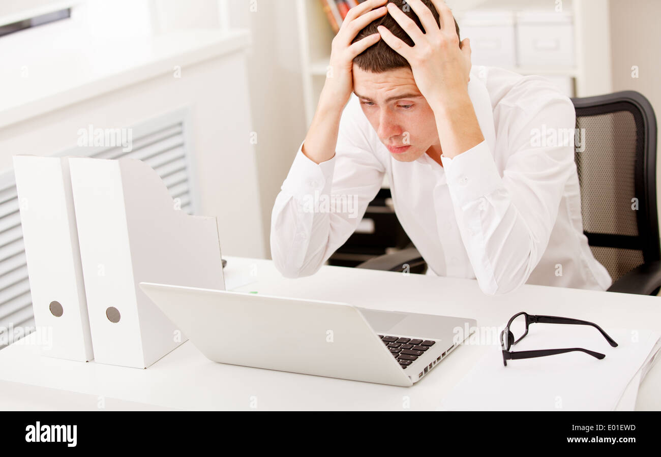 Verzweifelte Geschäftsmann am Schreibtisch Stockfoto