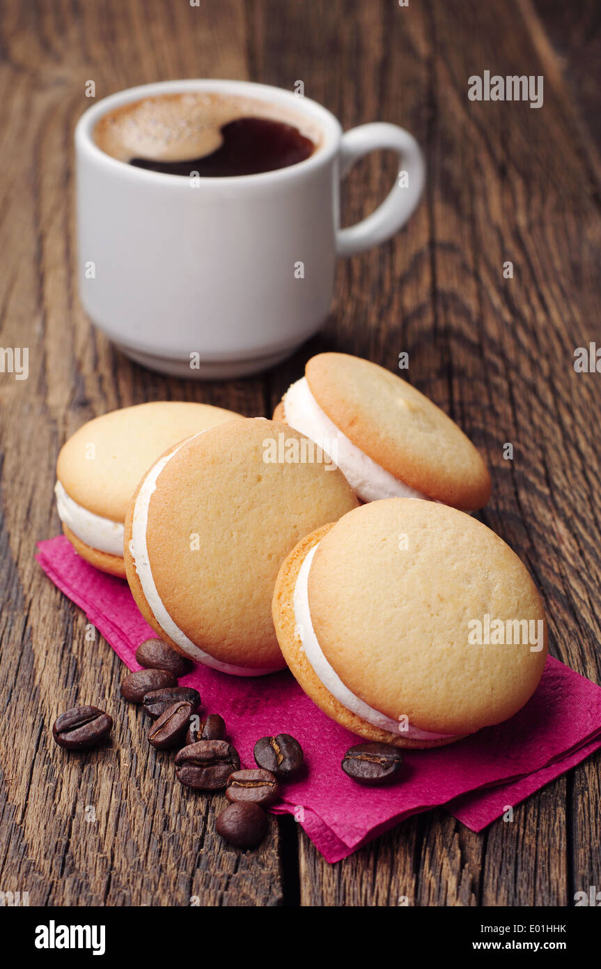 Cookies mit Marshmallows und Tasse Kaffee auf Holztisch Stockfoto
