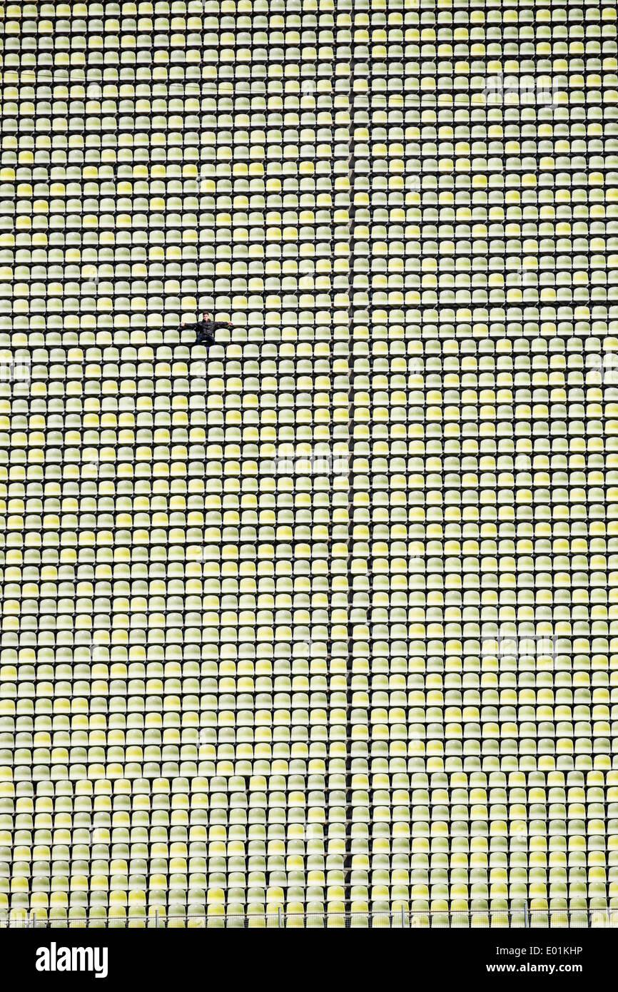 Eine Person sitzt in Sitze im ehemaligen Olympiastadion im Olympiapark in München Bayern Deutschland Stockfoto