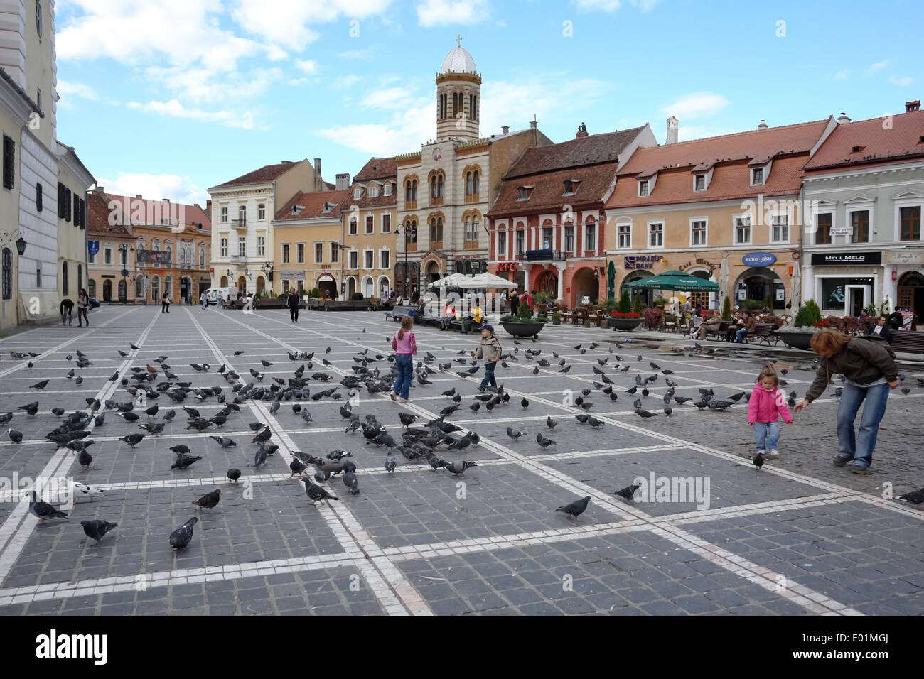 Die Vögel und die Menschen auf dem Rathausplatz in Brasov. Rumänien. Stockfoto