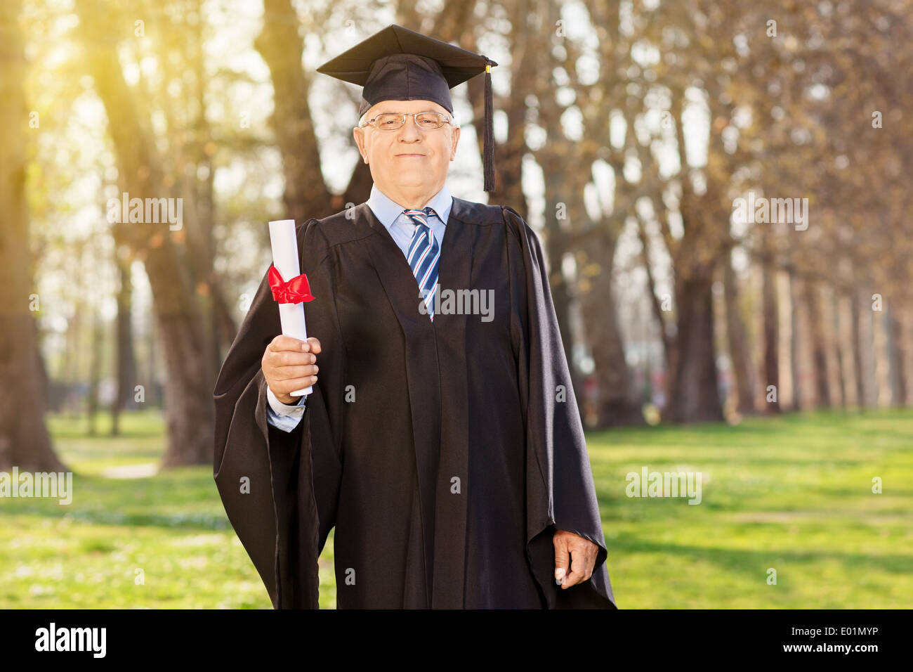 Stolz Erwachsener Schüler hält ein Diplom im freien Stockfoto