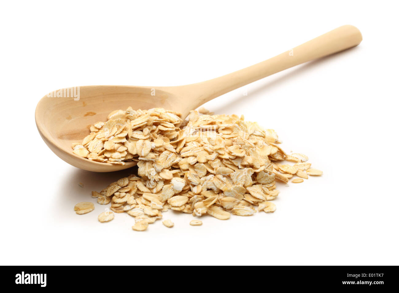 Haufen von Haferflocken mit einem Holzlöffel auf weiß Stockfoto
