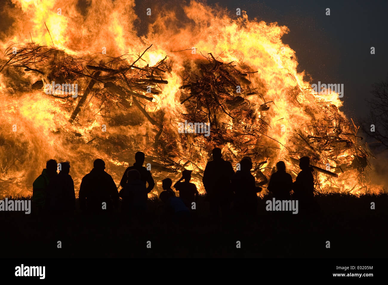 Menschen beobachten ein riesiges Feuer, eine Tradition mit Ostern in Nordwest-Europa. Stockfoto