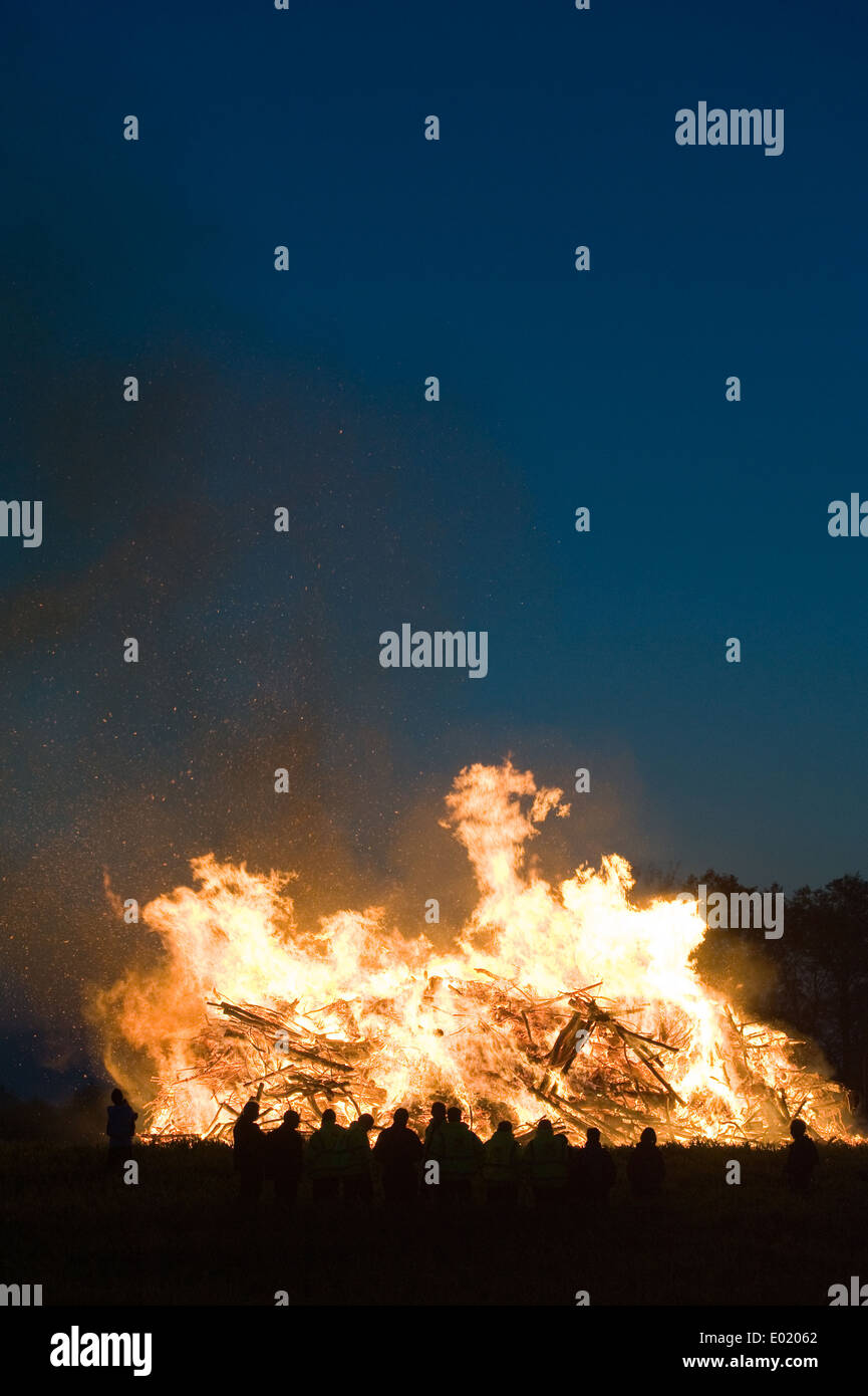 Menschen beobachten ein riesiges Feuer, eine Tradition mit Ostern in Nordwest-Europa. Stockfoto