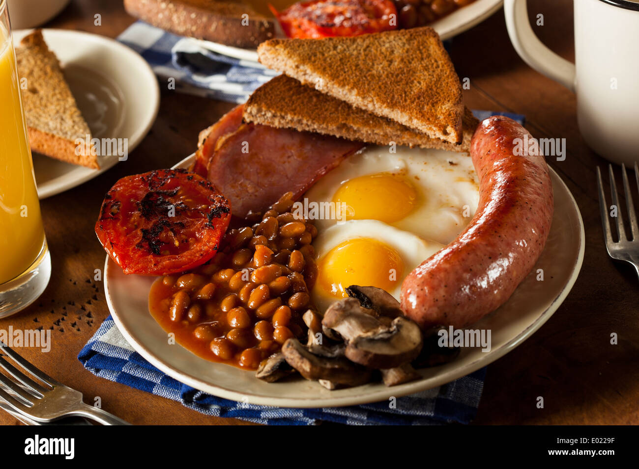 Traditionelle komplettes englisches Frühstück mit Eiern, Speck, Würstchen und gebackenen Bohnen Stockfoto