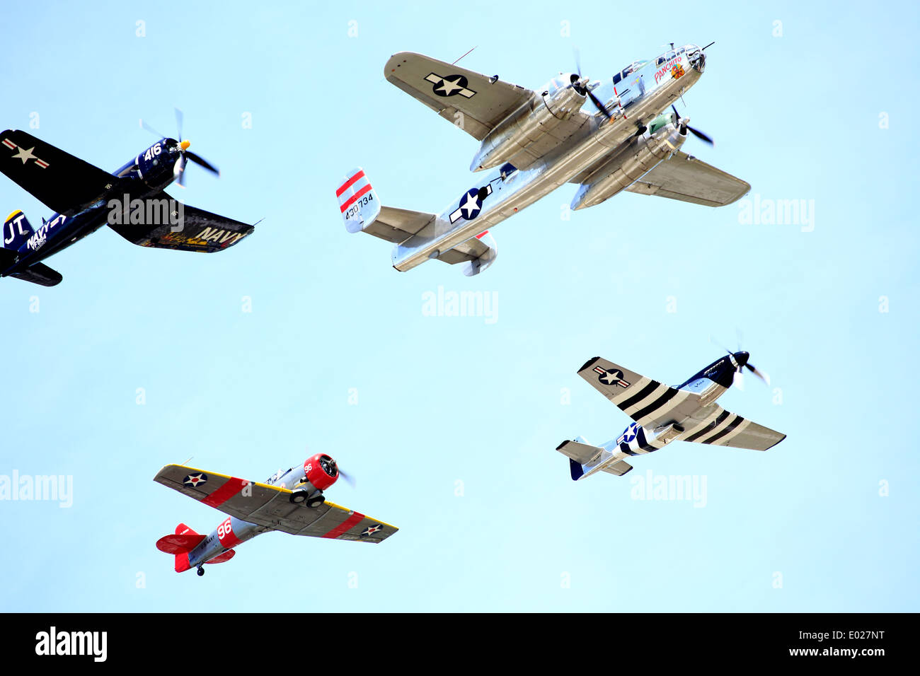 Vier 2. Weltkrieg Flugzeuge in Bildung; ein b-25 Bomber, ein Mustang, ein Corsair und eine SNJ T6 Texan Stockfoto