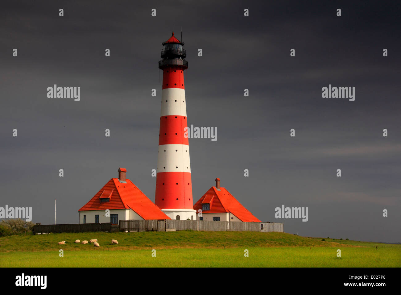 Foto der rot-weiss gestreifte Leuchtturm Westerheversand mit Sturm Himmel und Wolken, eiderstedt, Deutschland Stockfoto