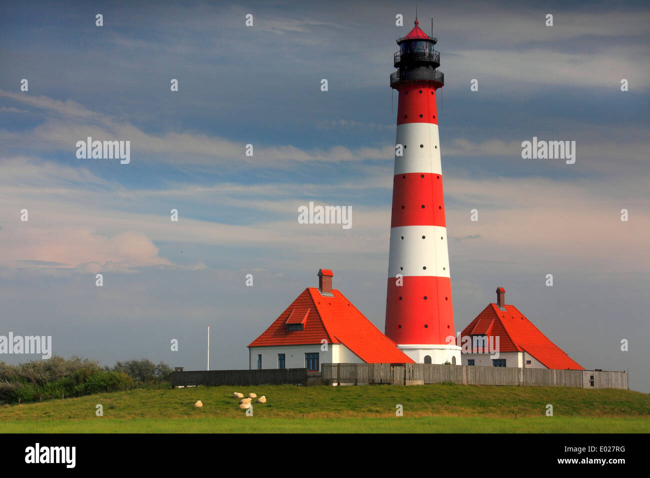 Foto der rot-weiss gestreifte Leuchtturm Westerheversand, eiderstedt, mit Sturm Himmel und Wolken, Deutschland Stockfoto