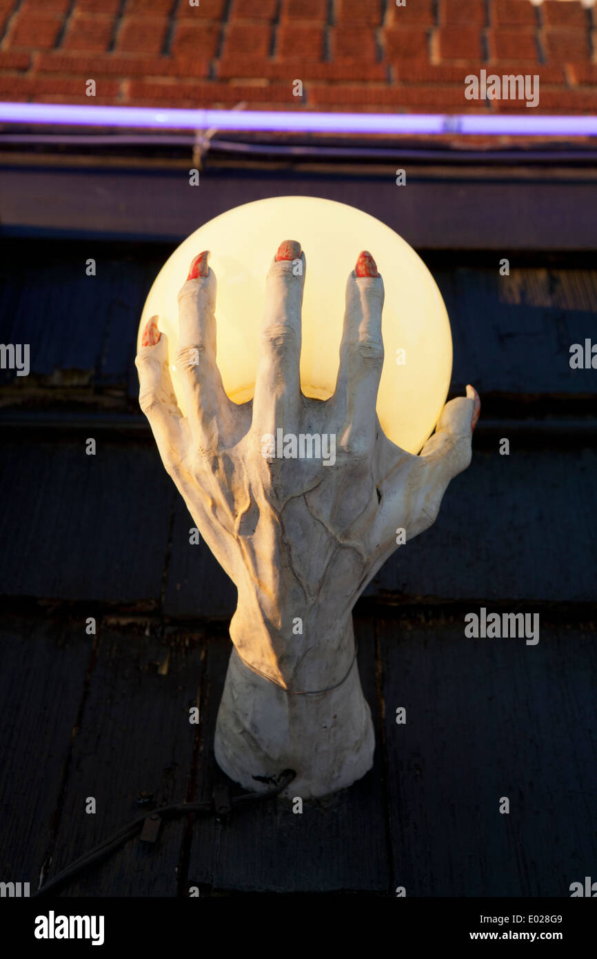 Knochige Hand tragen eine beleuchtete Kristallkugel. Stockfoto