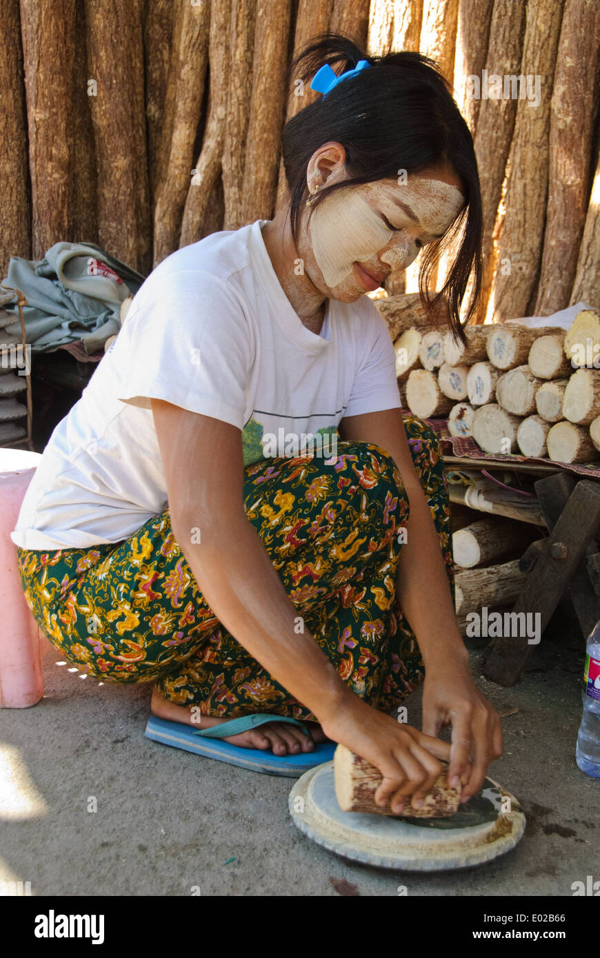 Ein burmesischen Mädchen reiben die Rinde des Thanaka auf einem Schleifstein. Stockfoto
