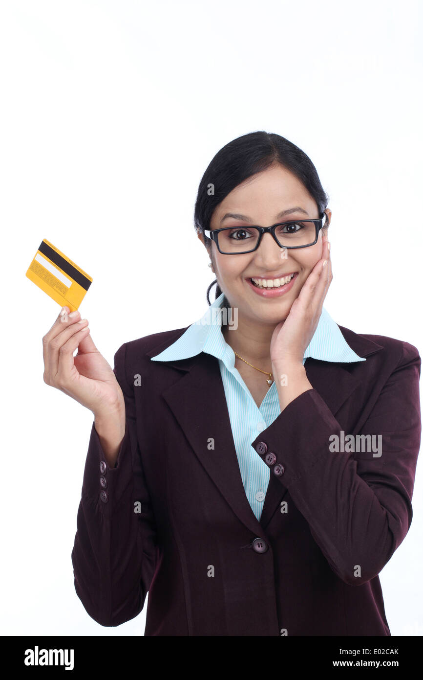 Überrascht junge Geschäftsfrau mit Kreditkarte vor weißem Hintergrund Stockfoto