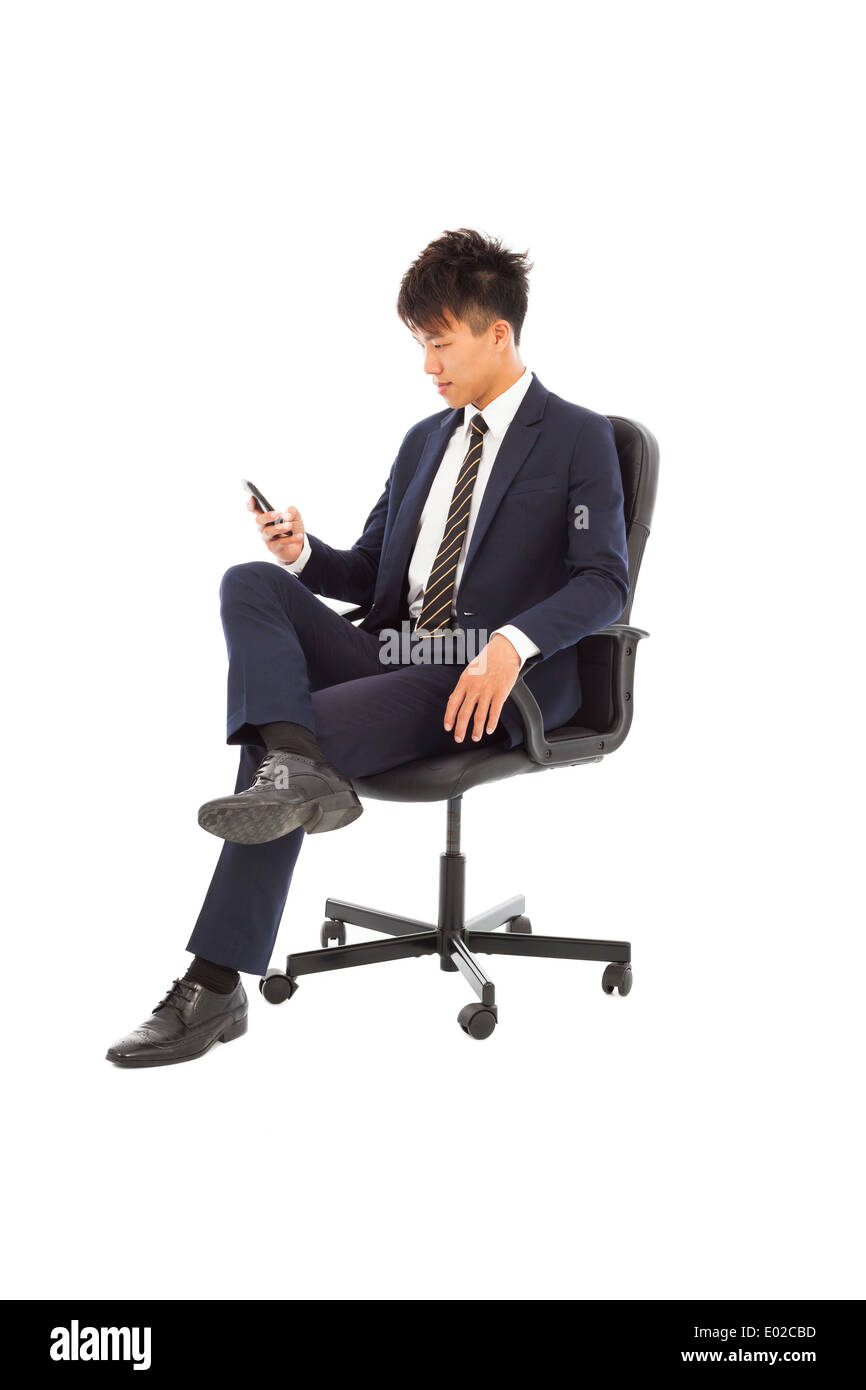 Junger Geschäftsmann in einem Stuhl sitzen und beobachtete smartphone Stockfoto