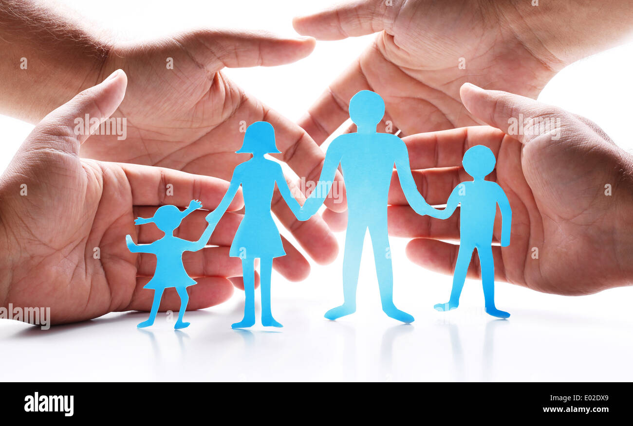 Pappfiguren der Familie auf einem weißen Hintergrund. Das Symbol der Einheit und des Glücks. Händen umarmen sanft die Familie. Stockfoto