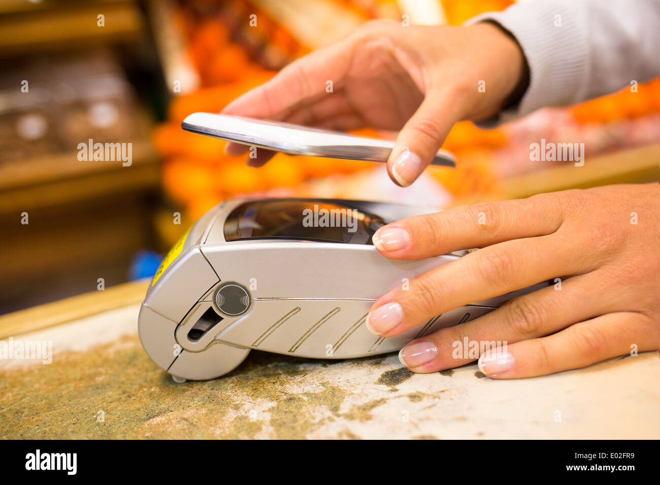 Weibliche elektronische Zahlungssysteme Nahaufnahme Handy Hand Shop elektronische Leser Stockfoto