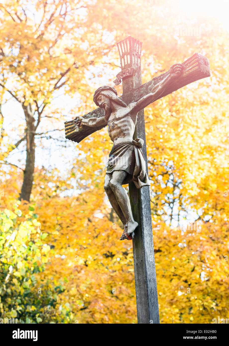 Jesus Christus am Kreuz mit Herbst Bäume im Hintergrund. Friedhof in Stockholm, Schweden. Stockfoto
