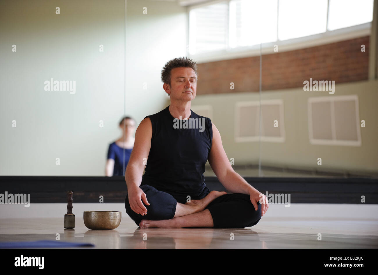 Ein Yoga-Lehrer und Klasse meditieren ein Birmingham Arts Centre Stockfoto