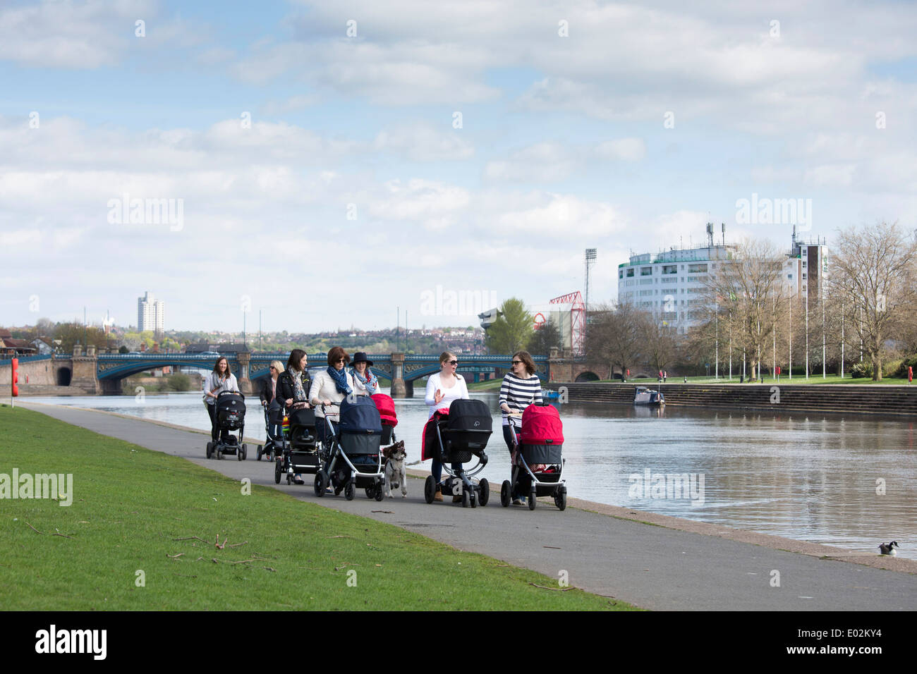 Eine Gruppe von Müttern, die Freunde, gehen mit ihren Kinderwagen auf dem Damm neben dem Fluss Trent in Nottingham, Großbritannien. Stockfoto