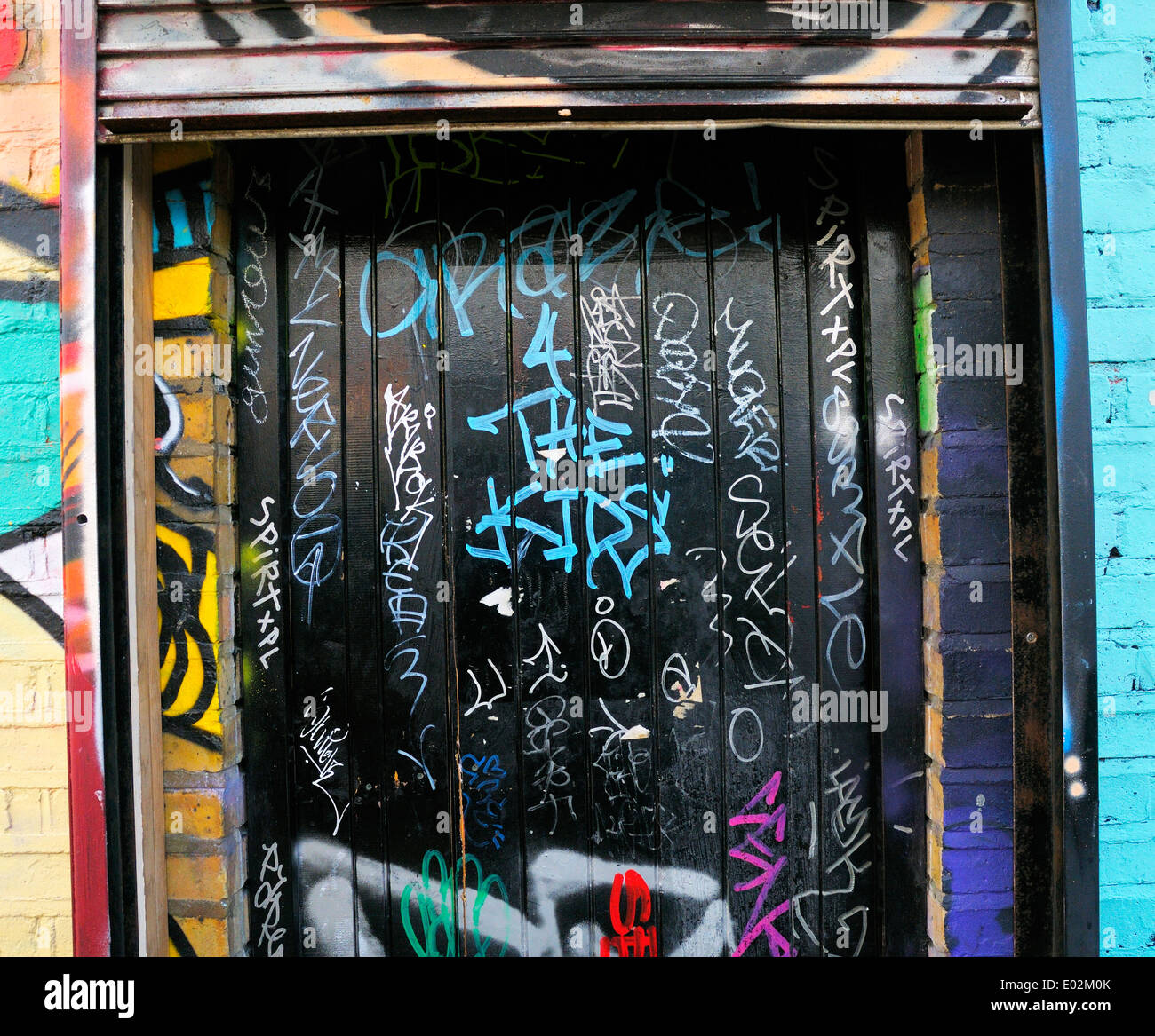 Graffiti-tags auf schwarze Tür Stockfoto