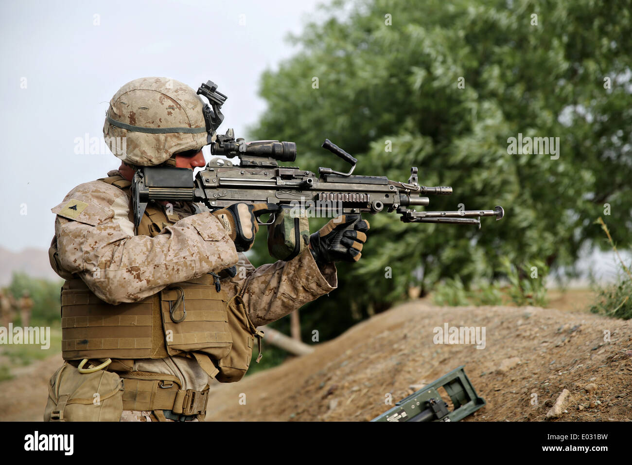 US Marine Lance Cpl. Jonathan Griffiths hält Uhr mit einer M249 Squad automatische Waffe während eines Clearing-Vorgangs mission 25. April 2014 in Larr Dorf, Provinz Helmand, Afghanistan. Stockfoto