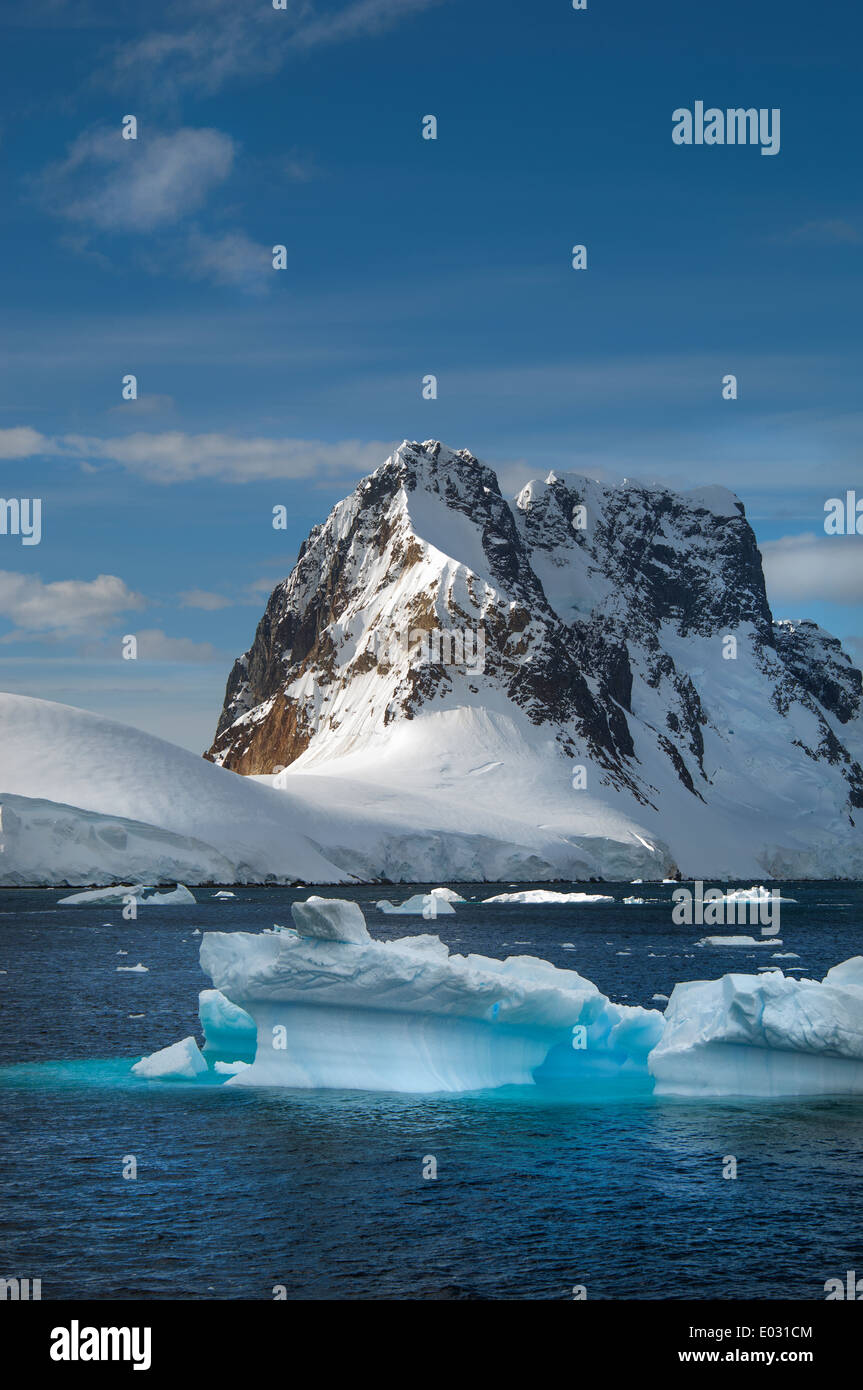 Eisberge im Wasser vor der felsigen Küste der Antarktis. Stockfoto