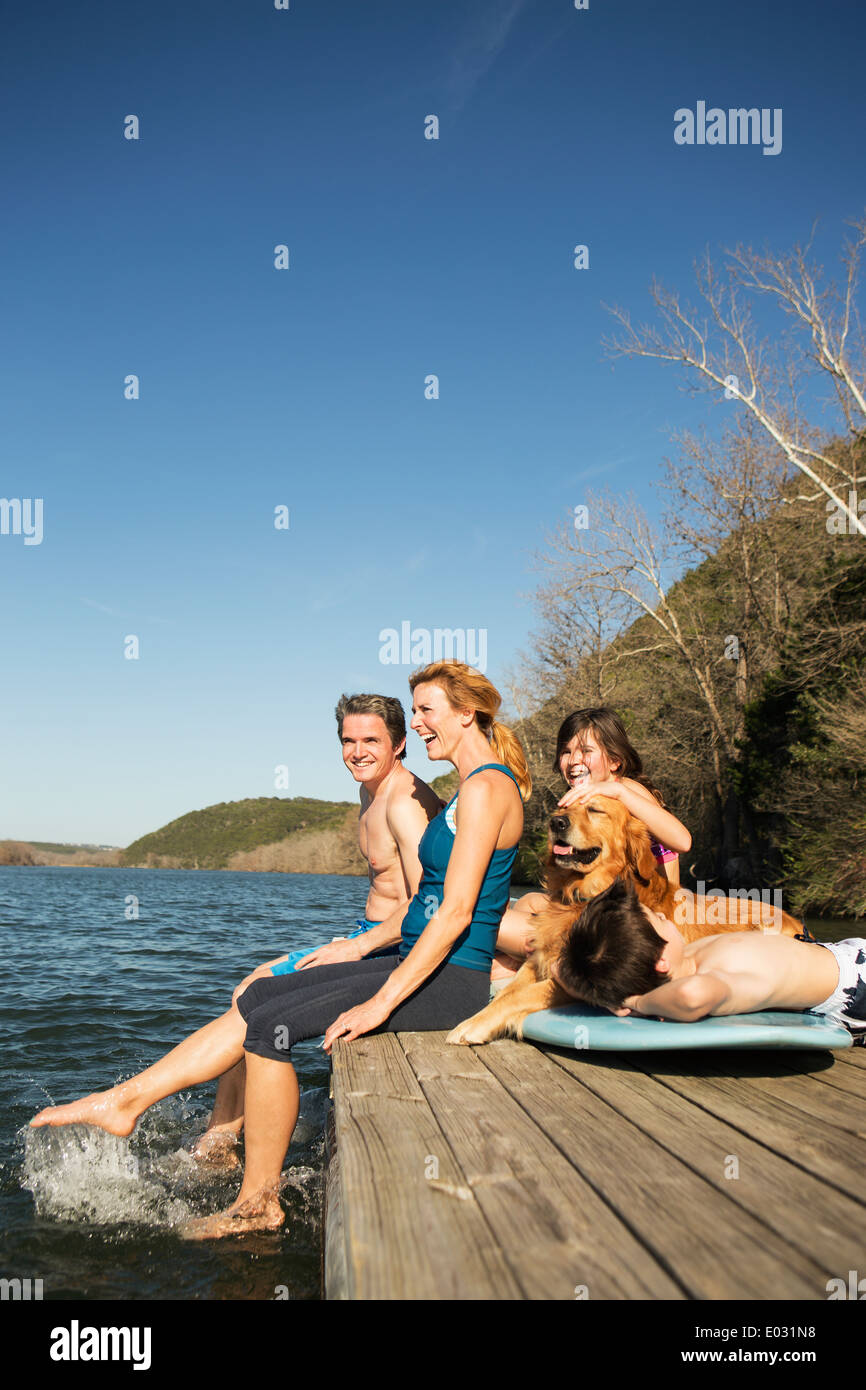 Eine Familie und ihre Retriever Hund auf einem Steg am See. Stockfoto
