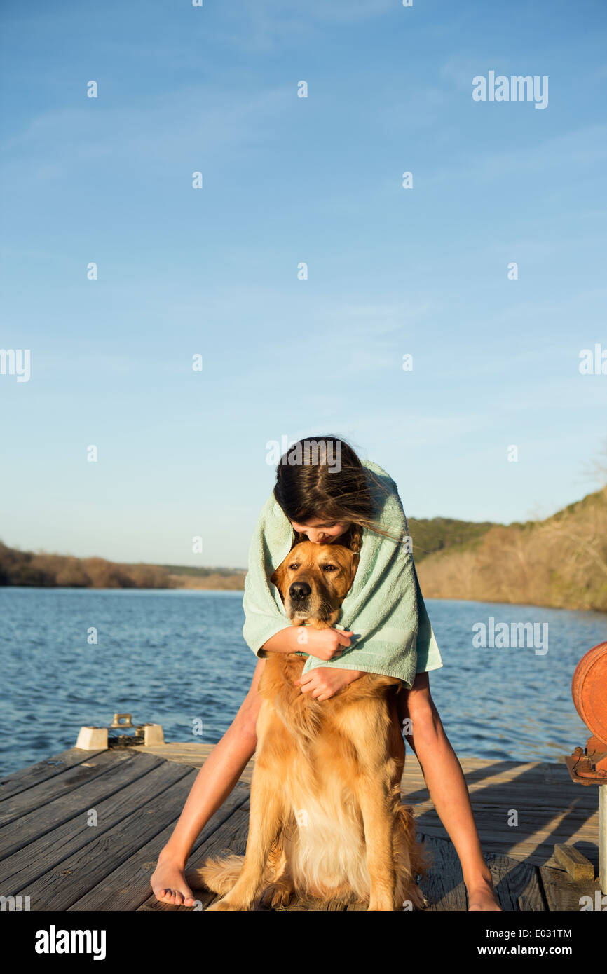 Ein Mädchen, einen golden Retriever Hund kuscheln. Stockfoto