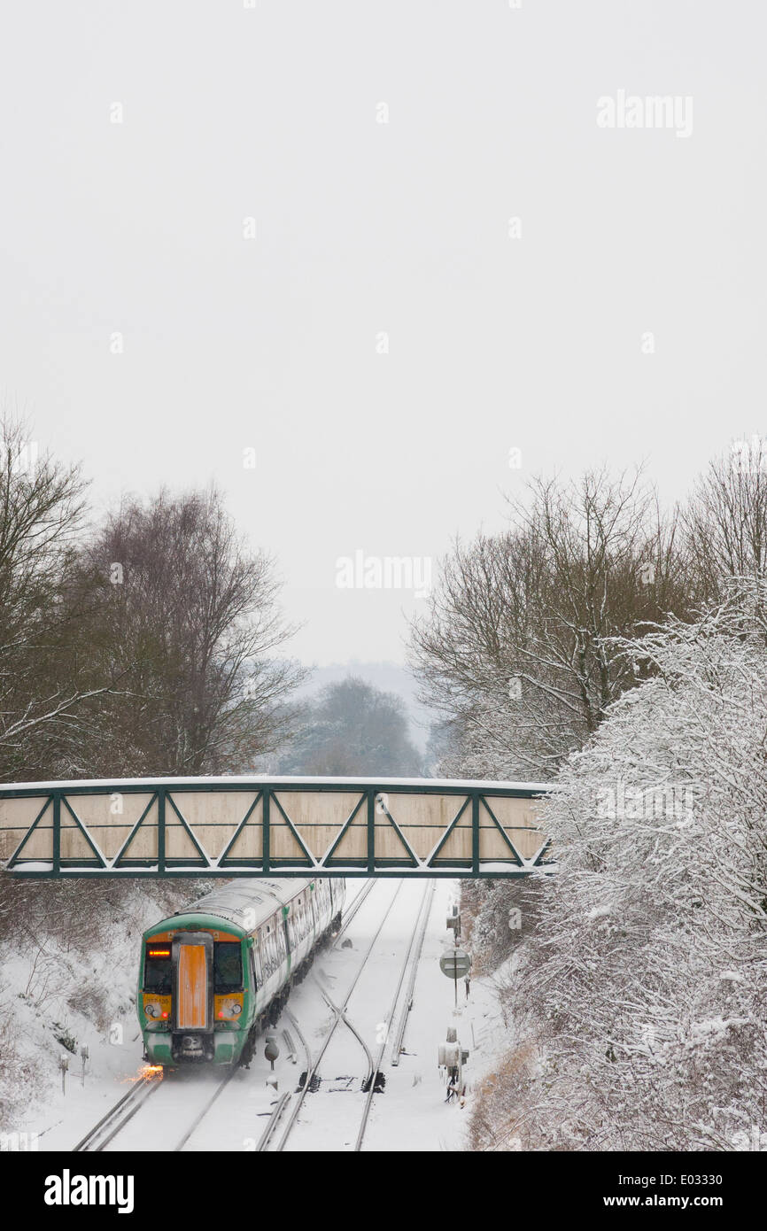 SURREY, UK A Train Dorking Bahnhof sendet eine Dusche der Funken im Schnee. Stockfoto