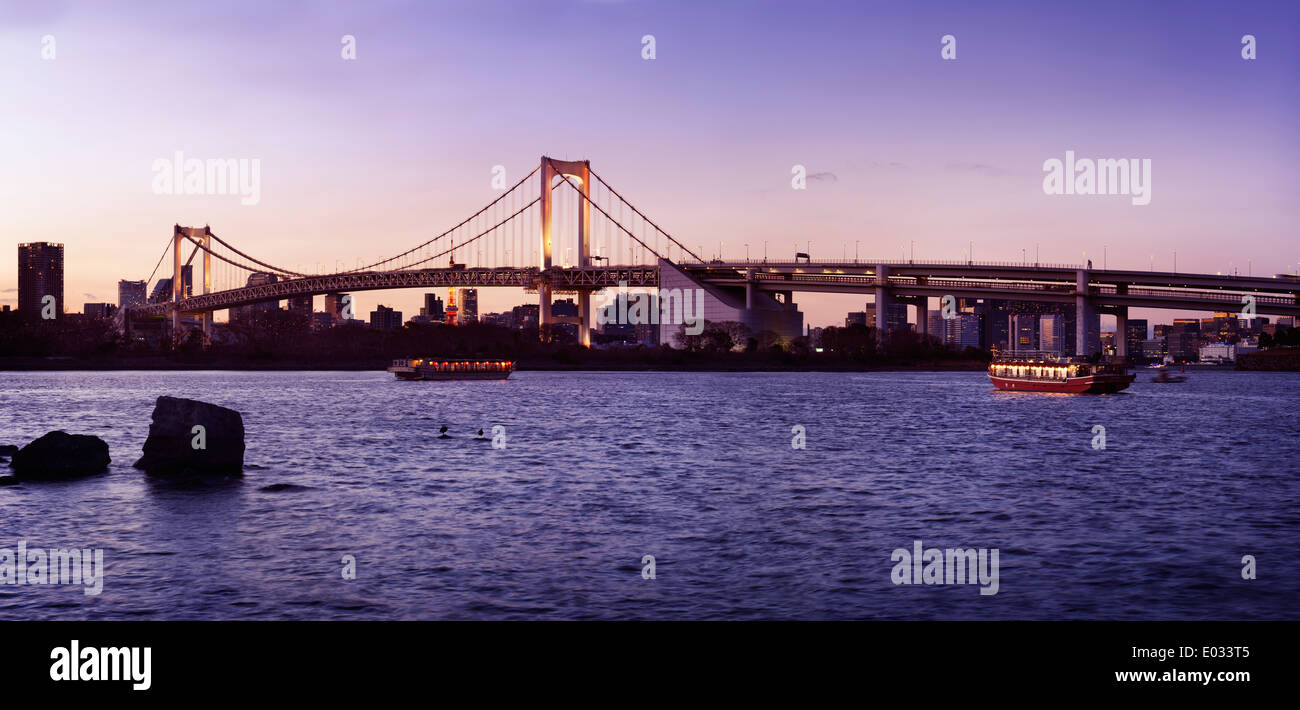 Panoramablick über die Regenbogenbrücke in Tokyo Bay bei Sonnenuntergang. Odaiba, Tokio, Japan. Stockfoto
