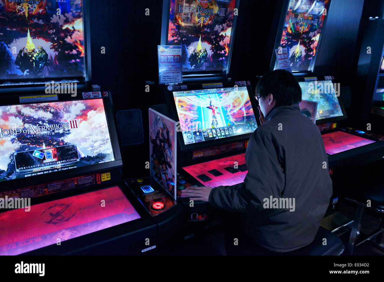 Person zu spielen Spielautomaten Lord of Vermilion Karte Arcade-Spiel in Tokio, Japan Stockfoto