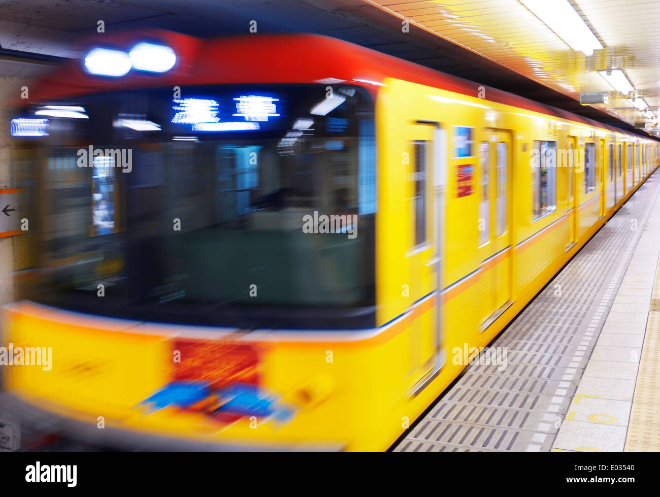 Tokyo Metro gelbe u-Bahn verschwommen aus der Bewegung zu einer Plattform ankommen. Tokio, Japan. Stockfoto