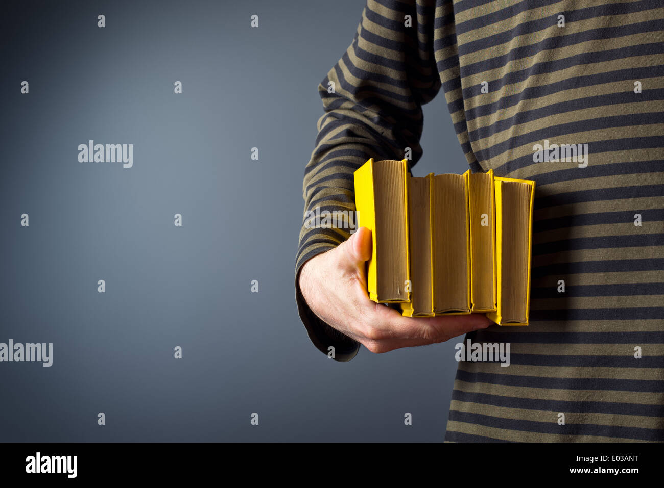 Legerer Mann Betrieb Stapel Alter gelb Hardcover Bücher Stockfoto