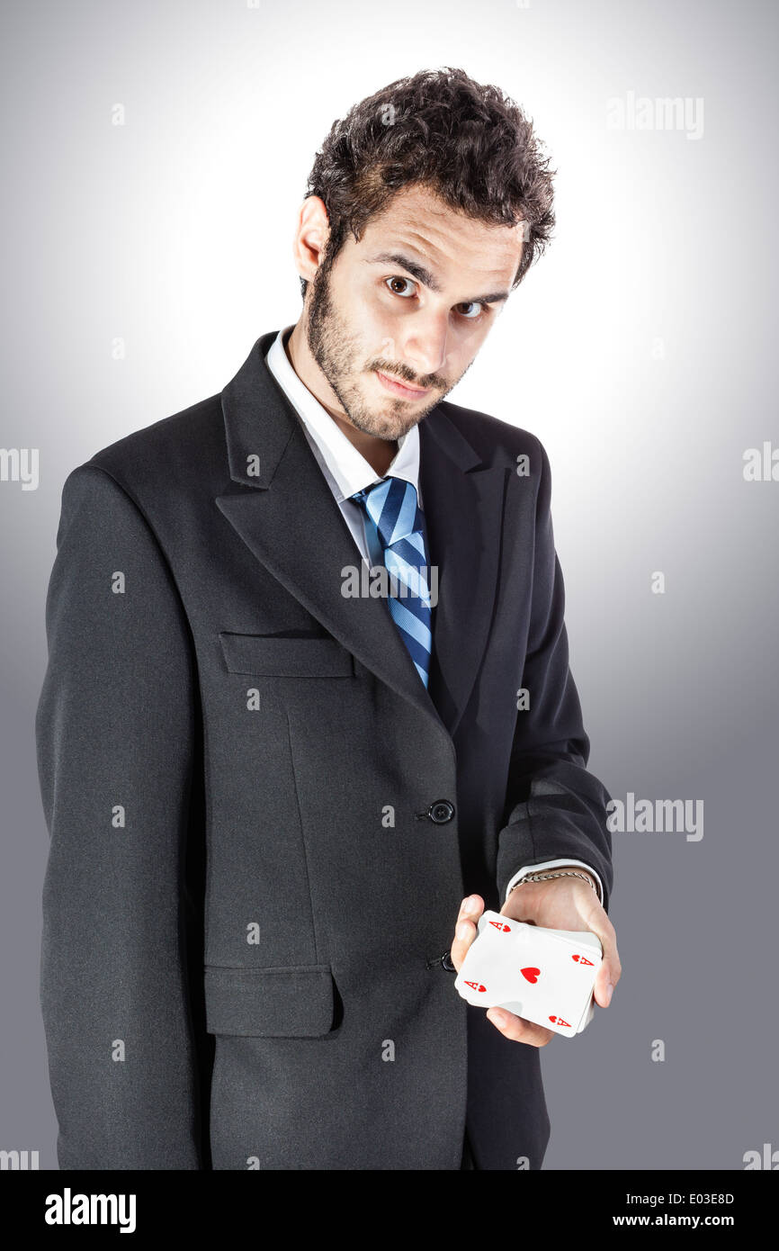 ein eleganter junger Geschäftsmann zeigt ein Herz-Ass in der hand Stockfoto