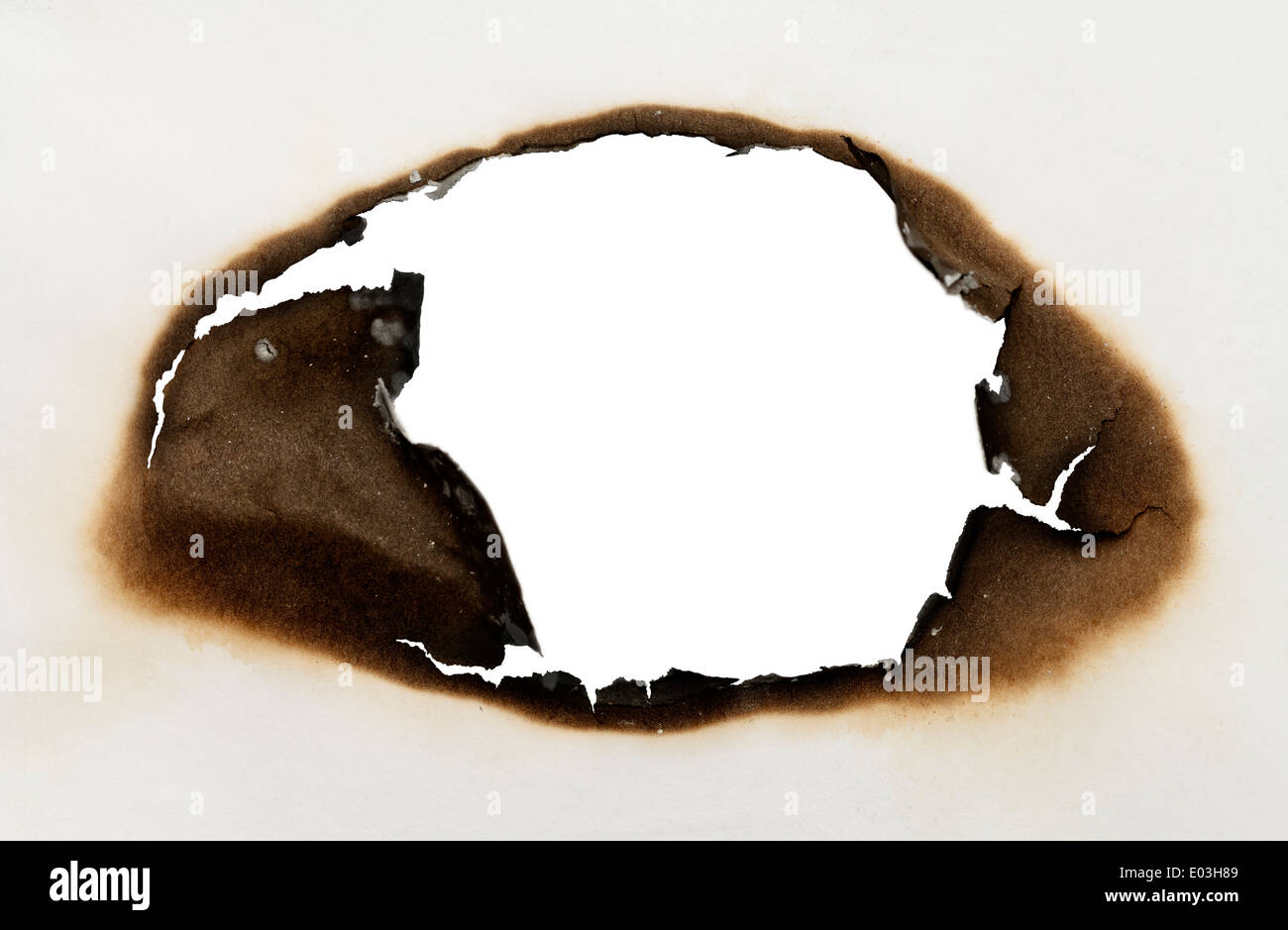 Stück Papier mit verbrannten Loch in ovaler Form mit weißem Hintergrund. Stockfoto