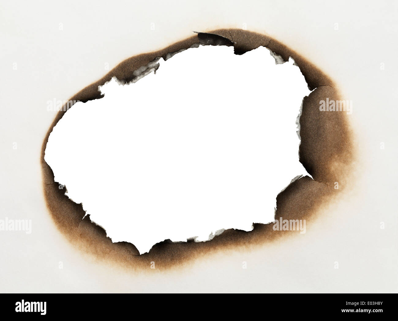Stück Papier mit verbrannten Loch in ovaler Form mit weißem Hintergrund. Stockfoto