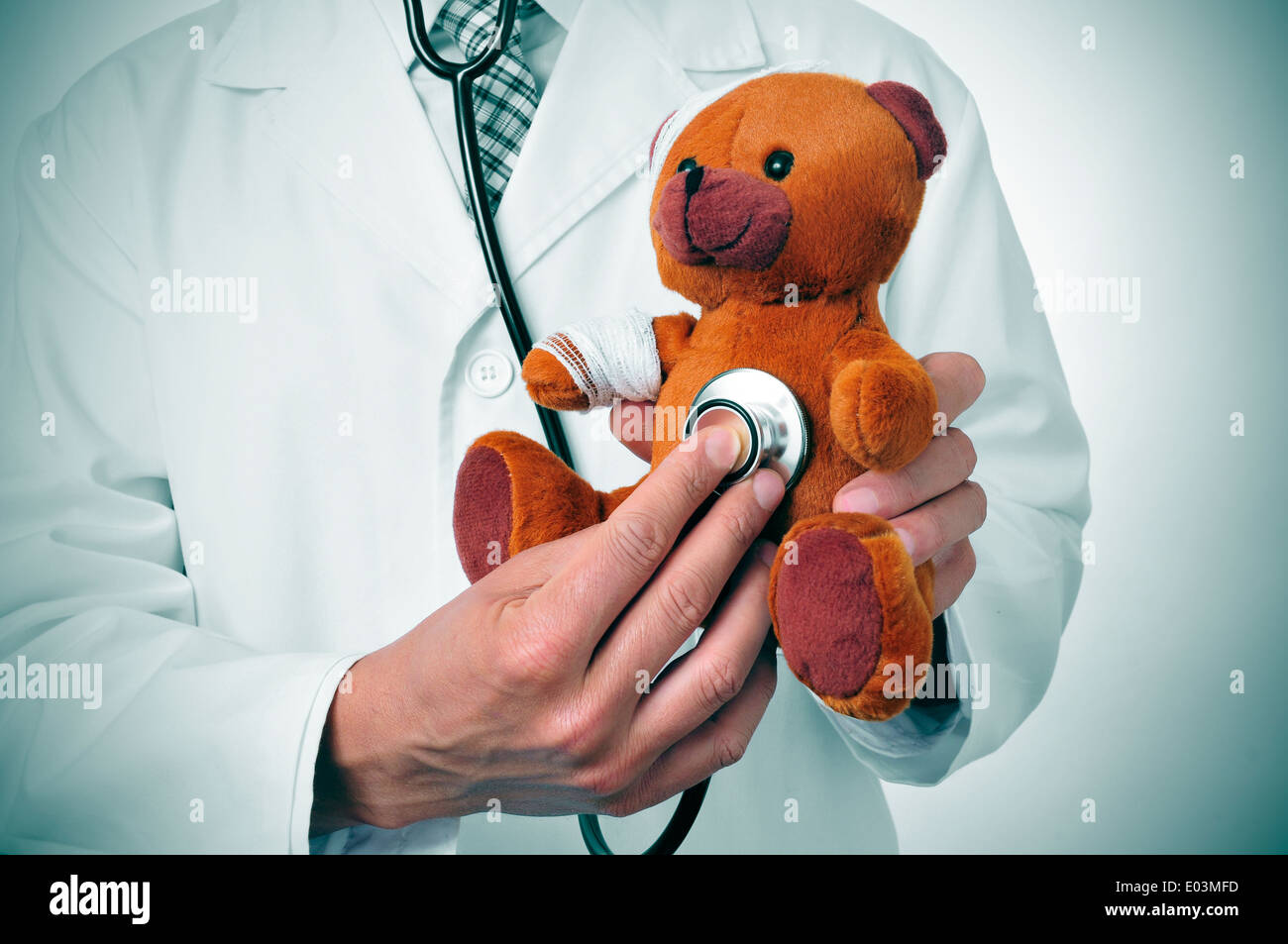 ein Arzt auskultieren einen Teddybär mit Bandagen in seinem Kopf und Arm, Darstellung der pädiatrischen Medizin oder der Veterinär Medizin Stockfoto