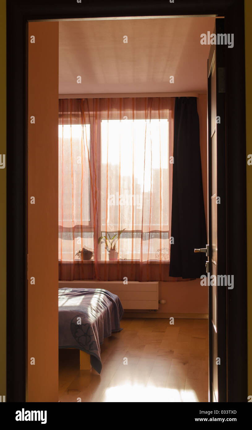 Schlafzimmer-Blick auf Bett Winkel Fenster mit Vorhängen von Sonnenlicht beleuchtet Stockfoto